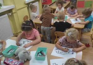 Dzieci kolorują ilustracje.